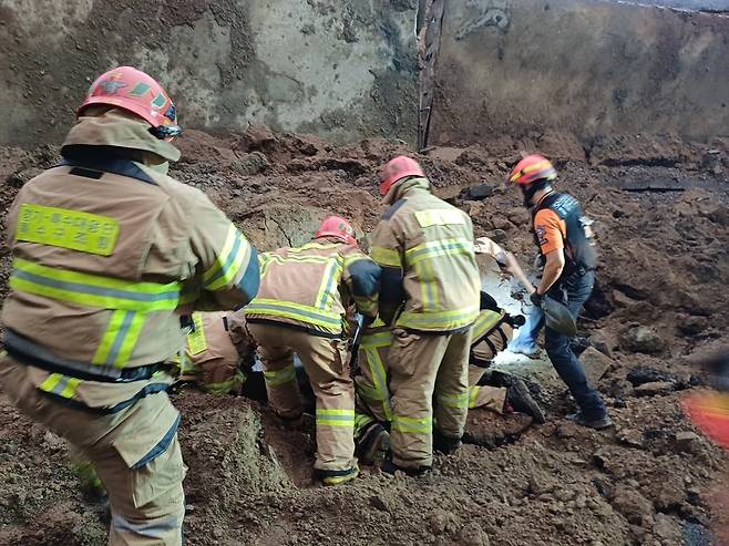 16일 경기 오산 가장교차로 고가도로 옹벽이 폭우로 인해 붕괴, 차량 2대가 깔리는 사고가 발생했다. 현재까지 인명 피해 여부는 정확히 확인되지 않고 있다. 사진은 이날 사고 현장에서 소방대원이 구조작업을 하는 모습. /뉴스1