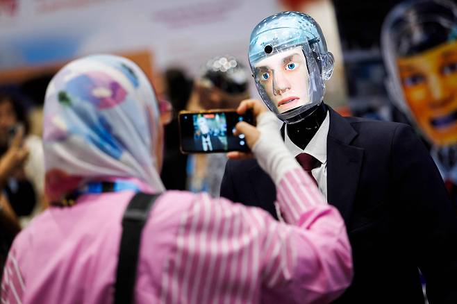 2025년 7월 스위스 제네바에서 열린 국제전기통신연합(ITU) AI 글로벌 정상회의에서 한 방문객이 핸슨 로보틱스 인공지능을 사용한 로봇 로버트를 찍고 있다. /연합뉴스