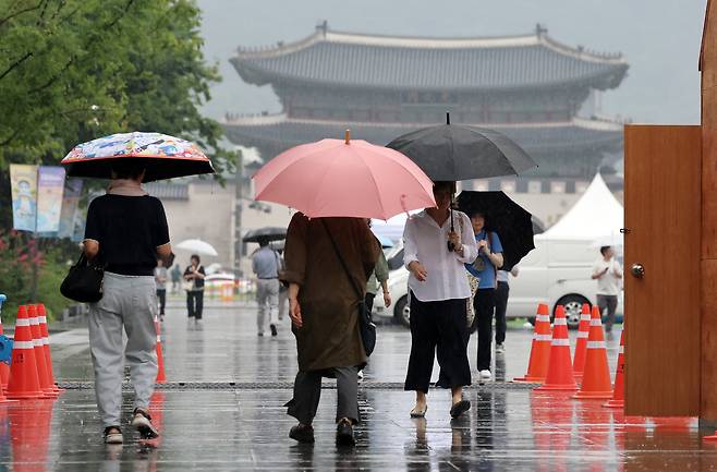 비가 내린 16일 서울 종로구 광화문광장에서 시민들이 우산을 쓴 채 발걸음을 옮기고 있다. /뉴스1