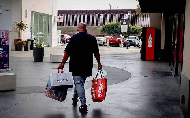 미국의 6월 소비자물가지수(CPI)가 시장 예상을 벗어나지는 않았지만 관세 충격이 서서히 물가를 압박하고 있는 것으로 15일(현지시간) 확인됐다. 지난해 11월 26일 캘리포니아주 샌이시드로 접경지대 쇼핑몰에서 한 소비자가 쇼핑백들을 들고 걸어가고 있다. AFP 연합