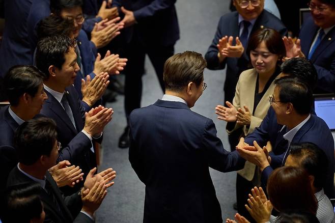 이재명 대통령이 지난 26일 서울 여의도 국회에서 추가경정예산(추경) 시정연설을 하기 앞서 더불어민주당 의원들과 인사를 나누고 있다. [이재명 대통령 SNS]