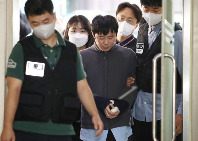 ‘신당역 스토킹 살인 사건’ 피의자 전주환이 2022년 9월21일 서울 중구 남대문경찰서에서 출감된 뒤 검찰로 구속 송치되고 있다. 사진공동취재단