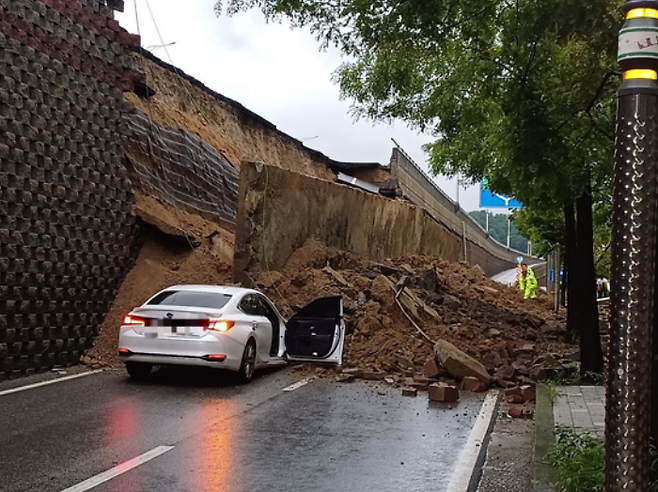 경기도 오산시 기장동 가장교차로 인근에서 16일 오후 7시4분쯤 약 10m 높이의 옹벽이 도로 쪽으로 무너지며 주행 중이던 차량을 덮친 모습. 경기도소방재난본부 제공
