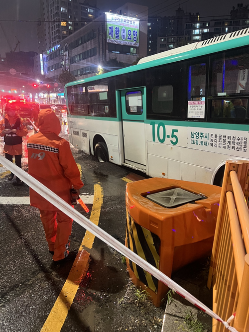 경기도 구리시 인창동 임창삼거리에서 16일 오후 8시6분쯤 버스 뒷바퀴가 포트홀에 고립되는 사고가 발생해 소방당국이 안전조치를 하고 있다. 경기도소방재난본부 제공