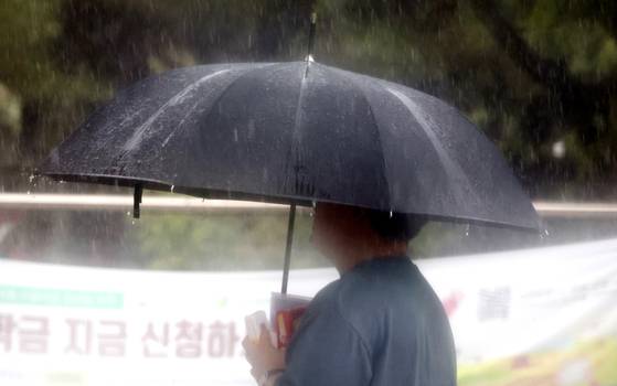 A person walks in the rain on the Jeonbuk National University campus in Jeonju, North Jeolla, on July 16. [NEWS1]