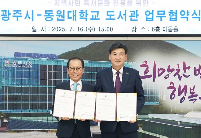 방세환 경기 광주시장(오른쪽)이 16일 시청 이음홀에서 동원대학교 이종원 총장과 지역 독서문화 확산을 위한 업무협약을 체결하고 협약서를 들고 사진촬영을 하고 있다. /사진제공=광주시