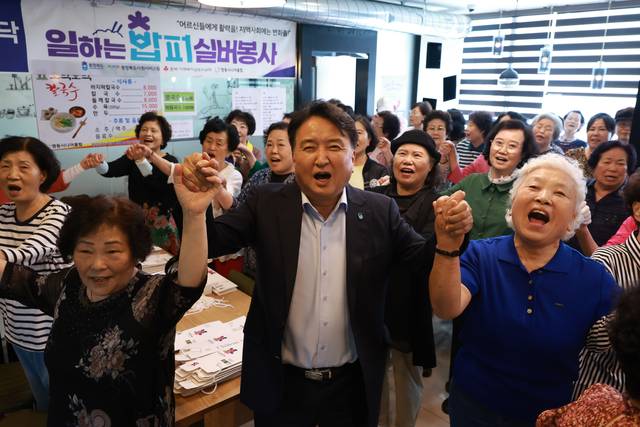 김영환(가운데) 충북지사가 일하는 밥퍼 사업장에서 봉사에 나선 어르신들과 환하게 웃고 있다.  충북도청 제공