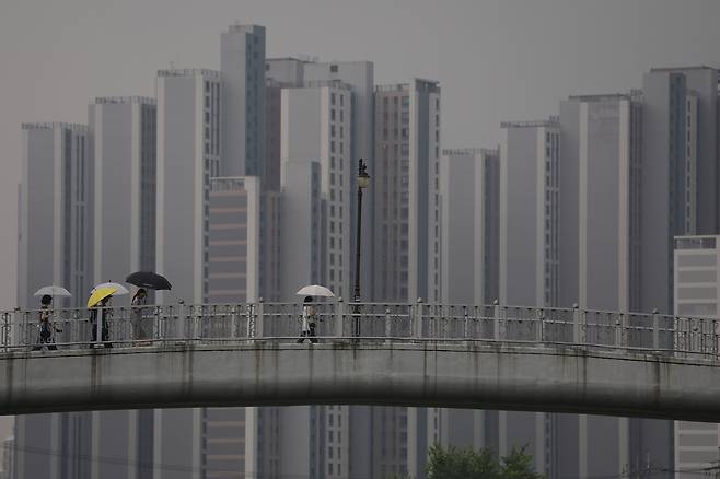 전국에 비가 내린 16일 오전 경기도 의정부시 중랑천에서 시민들이 우산을 쓰고 이동하고 있다.  [연합]