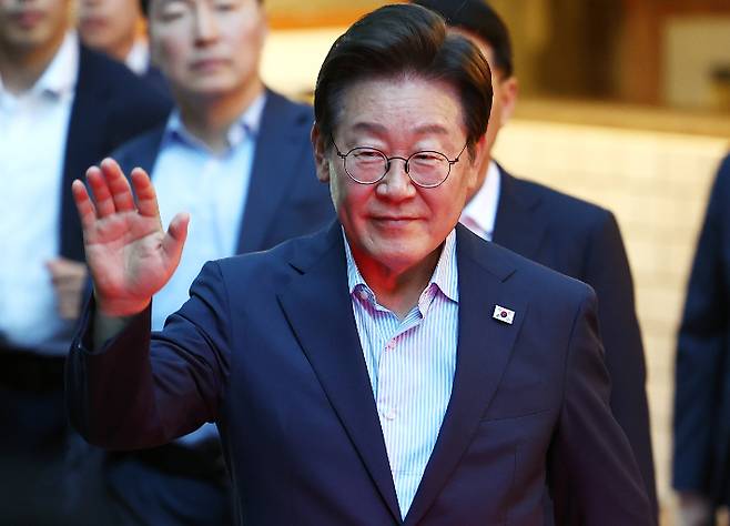 이재명 대통령이 11일 저녁 서울 광화문 인근 한식당에서 나오며 시민들에게 손을 흔들고 있는 모습. 연합뉴스