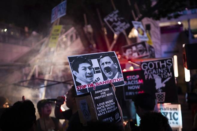 지난 13일 일본 도쿄 신주쿠에서 국민주의 정당 ‘참정당’에 반대하는 ‘프로테스트 레이브(항의 레이브)’에 참가한 시위자들. 도쿄 AP 뉴시스