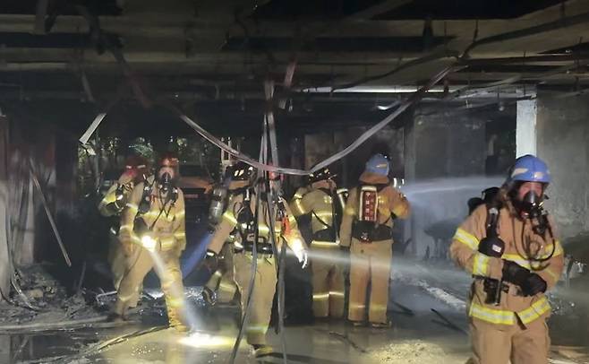 17일 오후 광명시 소하동의 한 10층짜리 아파트 1층 필로티 주차장에서 화재가 발생한 가운데 소방대원들이 화재 현장을 살펴보고 있다. 사진=경기도소방재난본부