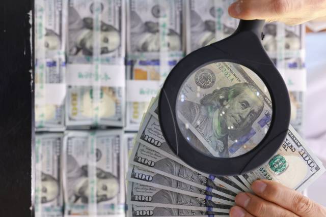 사진은 지난 4일 서울 중구 하나은행 본점 위변조대응센터에서 직원이 미국 달러화를 들어 보이는 모습. 연합뉴스