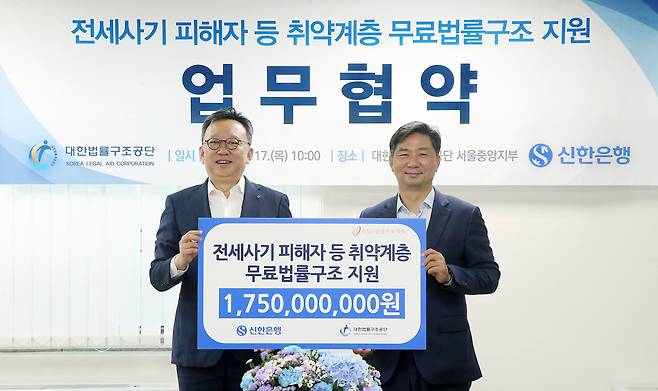 17일 서울 서초구 소재 대한법률구조공단 서울중앙지부에서 전세사기 피해자 등 취약계층 무료 법률구조 지원을 위해 후원금 17억 5000만 원을 전달하고 정상혁 신한은행장(왼쪽), 김영진 대한법률구조공단 이사장이 기념 촬영하는 모습.(신한은행 제공)