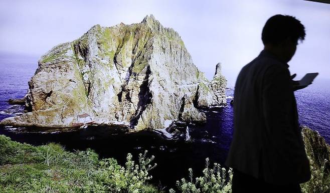 15일 서울 광화문 동북아역사재단 독도체험관에서 시민이 독도 사진 앞을 지나고 있다. 일본 정부는 "독도는 일본 고유의 영토"라는 주장을 펴온 방위백서의 어린이판 약 6천100권을 전국 초등학교에 배포했다. 연합뉴스