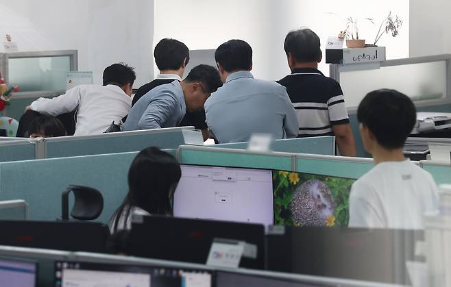 김건희 여사에 관한 의혹들을 수사하는 민중기 특별검사팀이 14일 '양평고속도로 노선변경 특혜 의혹'과 관련해 국토교통부 등 10여곳에 대한 전방위 압수수색에 나섰다.    이날 서울 성동구 동해종합기술공사 성수 본사에서 특검 관계자들이 자료를 살피고 있다./연합뉴스