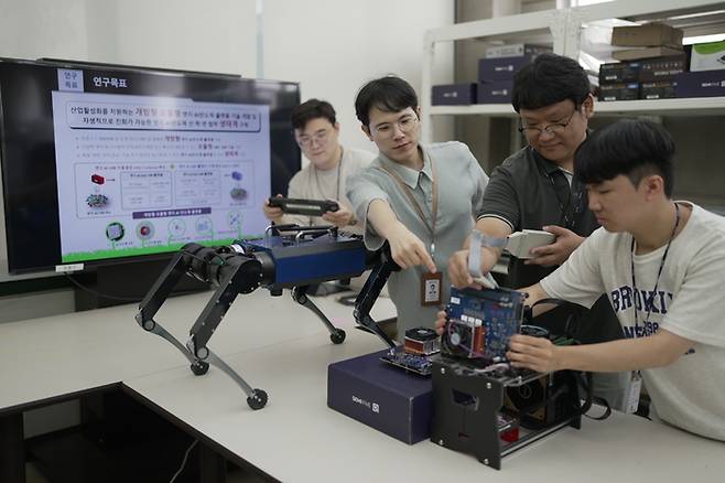 ETRI 연구진이 가이드독 로봇과 엣지 AI 반도체 플랫폼을 활용한 기술을 시연하는 모습