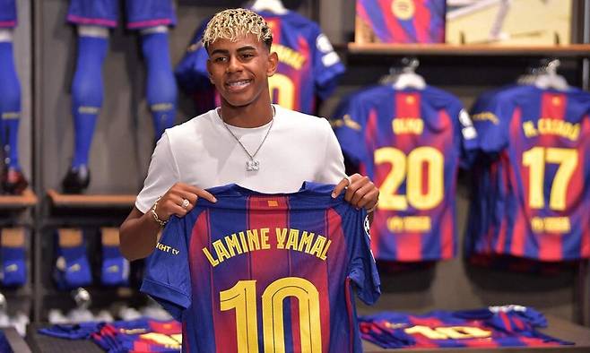 라민 야말이 16일(현지시각) 소속팀 FC바르셀로나의 누캄프 경기장에 있는 상점에서 자신의 10번 유니폼을 들고 있다. 바르셀로나/AFP 연합뉴스