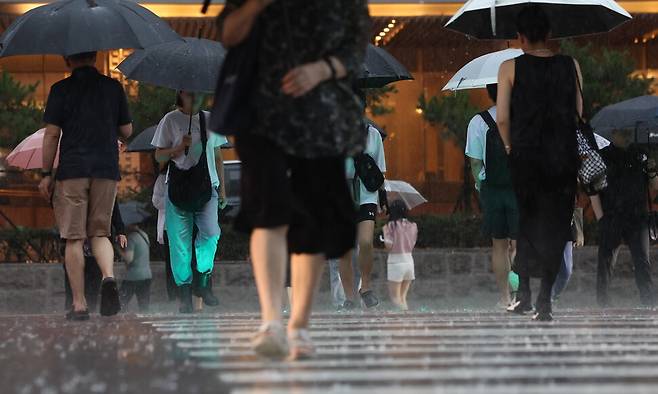 돌풍과 천둥·번개를 동반한 강한 비가 내리는 17일 서울 마포구 도로에서 시민들이 이동하고 있다. 연합뉴스