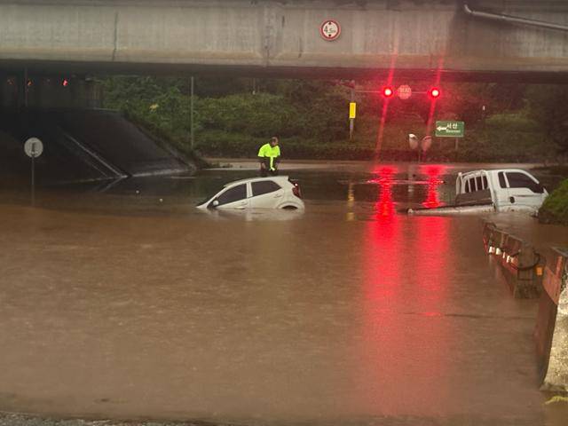 17일 오전 호우경보가 내려진 충남 서산시 운산면 운산교차로 지하차도에 침수가 발생해 차량 2대가 물에 잠겨있는 가운데 스파크 운전자가 차 위에서 구조를 기다리고 있다. 뉴시스