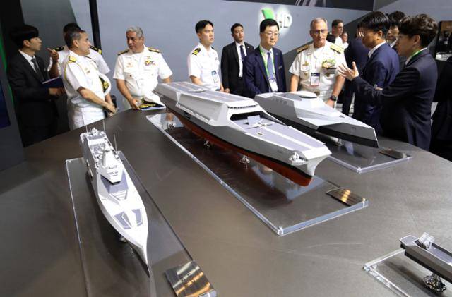 5월 28일 부산 해운대구 벡스코에서 열린 국제해양방위산업전(MADEX)을 찾은 참관객들이 HD현대중공업 부스의 미래형 무인전력모함을 살펴보며 이야기를 나누고 있다. 부산=뉴스1