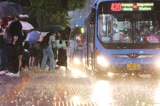 호우주의보가 내려진 16일 서울 강남역 인근에서 시민들이 버스를 기다리고 있다. 연합뉴스