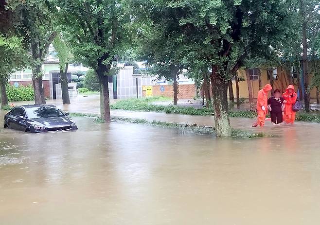 17일 오후 전남 담양군 고서중학교 인근 도로가 물에 잠겨 소방 당국이 안전 조치를 하고 있다. 연합뉴스