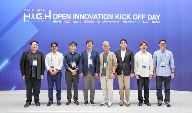2025 현대홈쇼핑 H.I.G.H 오픈 이노베이션 킥오프 데이에서 좌측부터 김민준 랭코드 대표, 윤정훈 퍼플아이오 대표, 전종찬 서울경제진흥원 책임, 한광영 현대홈쇼핑 대표이사, 홍경표 마크앤컴퍼니 대표, 강병희 차봇모빌리티 부대표, 이지혁 제트에이아이 대표, 현준엽 로쉬코리아 대표가 기념 촬영을 하고 있다. 현대홈쇼핑