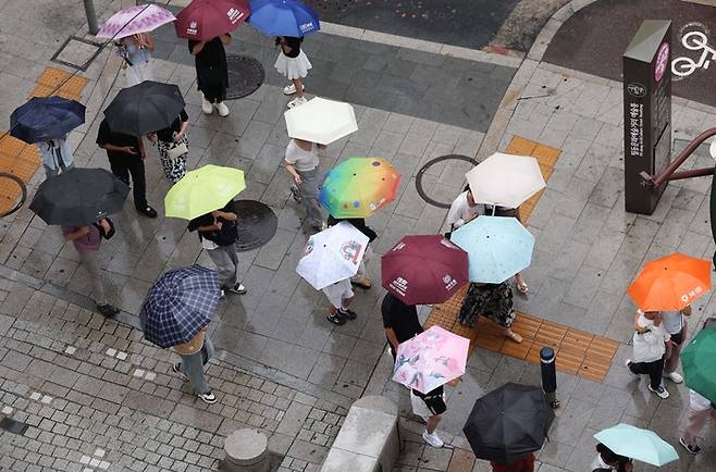 전국적으로 호우가 내린 지난 16일 서울 충무로역 일대 건널목에서 시민들이 우산을 쓴 채 걷고 있다. [한주형 기자]