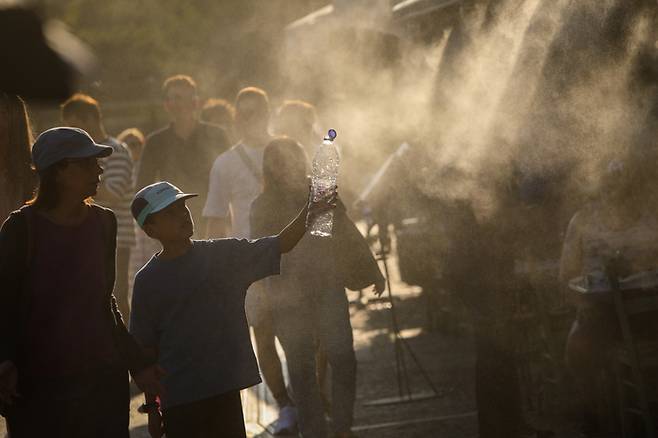 9일 그리스 아테네에 폭염이 지속되는 가운데 관광객들이 물 분사 장치가 있는 테라스를 지나가고 있는 모습. [사진 = EPA 연합뉴스]