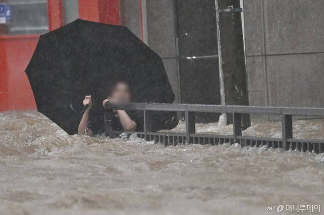 [광주=뉴시스] 이영주 기자 = 광주지역에 하루 최고 311㎜ 폭우가 쏟아진 17일 오후 침수된 광주 북구청 앞 도로에서 한 시민이 물살에 휩쓸리고 있다. 2025.07.17.