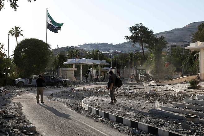 시리아 군 관계자가 16일(현지시간) 일부 부서진 국방부 청사를 촬영하고 있다. [AFP]