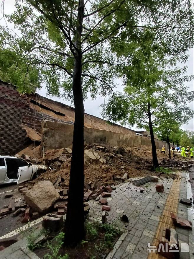 [오산=뉴시스] 김종택 기자 = 수도권 등 중부지역에 호우주의보가 발효된 16일 경기 오산시 가장교차로 옹벽이 도로로 무너져 차량을 덮치는 사고가 발생해 소방 당국이 대응 1단계를 발령, 구조작업을 벌이고 있다. (사진=경기도소방재난본부 제공) 2025.07.16. photo@newsis.com