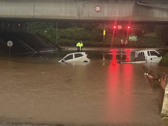 [서산=뉴시스] 17일 오전 호우경보가 내려진 충남 서산시 운산면 운산교차로 지하차도에 침수가 발생해 차량 2대가 물에 잠겨있는 가운데 스파크 운전자가 차 위에서 구조를 기다리고 있다. (사진=독자 제공) 2025.07.17. photo@newsis.com *재판매 및 DB 금지