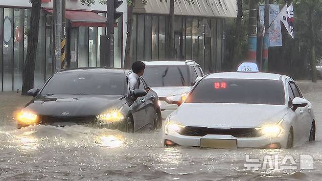 [광주=뉴시스] 이영주 기자 = 광주지역에 시간당 86㎜ 폭우가 쏟아진 17일 오후 광주 북구청 앞 교차로에서 차량들이 폭우로 넘치는 빗물에 갇혀 오가지 못하고 있다. 2025.07.17. leeyj2578@newsis.com