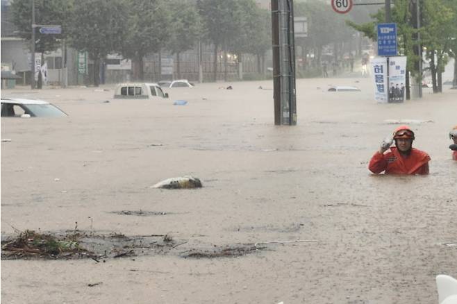 17일 오후 폭우로 광주 북구 신안동을 흐르는 서방천이 범람하면서 인근 도로가 완전히 침수됐다. 구조대원들이 차량이 물에 잠긴 도심 한복판에서 구조 작업을 벌이고 있다. 독자 제공