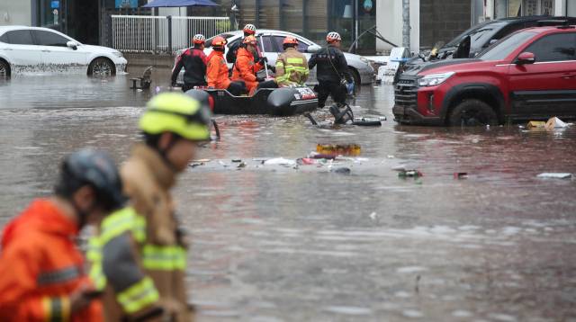 17일 대구 북구 노곡동에서 119구조대가 보트를 타고 인명 수색을 하고 있다. 이날 갑작스러운 폭우로 노곡동 일대가 침수됐다. 연합뉴스