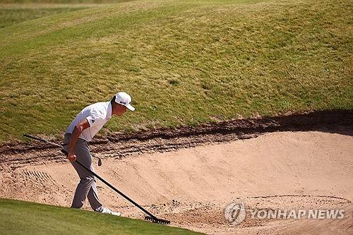 연습 라운드 도중 벙커를 정리하는 콜린 모리카와. [AP=연합뉴스]