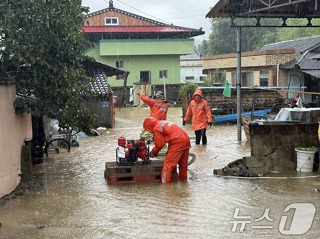 17일 오후 경남 밀양시 무안면에서 집중호우로 인해 침수된 주택에 출동한 소방대원들이 배수작업을 하고 있다. (소방청 제공. 재판매 및 DB 금지) 2025.7.17/뉴스1