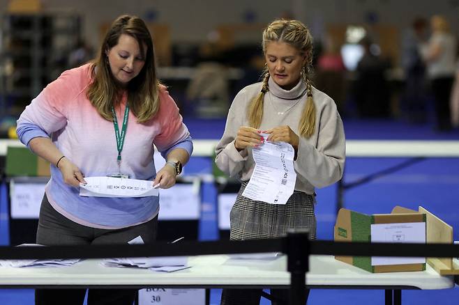 2022년 5월 영국 스코틀랜드 글래스고에서 열린 지방의회 선거에서 선거관리요원들이 투표를 하고 있다. /연합뉴스