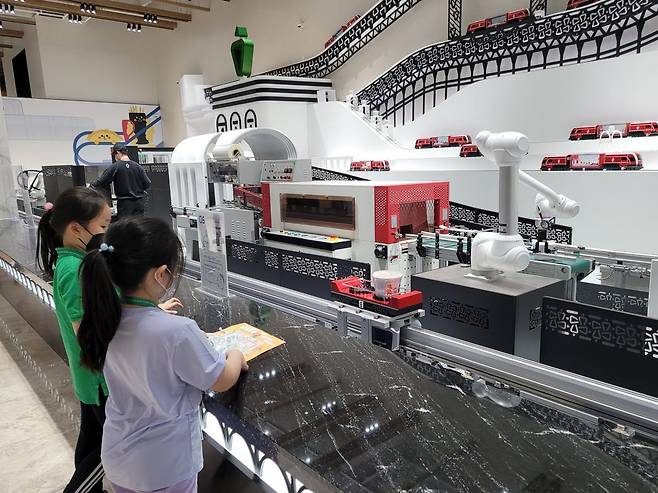 대구 북구의 세계 최초 떡볶이 박물관인 신전뮤지엄을 찾은 어린이들이 로봇과 함께 자신만의 떡볶이 밀키트를 만들고 있다.