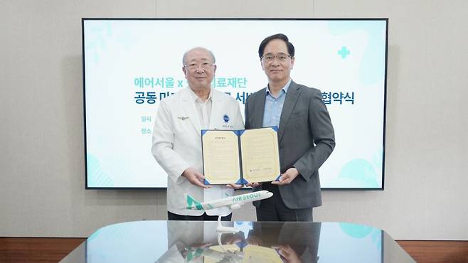 김중호 에어서울 대표이사(오른쪽)가 지난 17일 제주한라병원에서 진행된 에어서울과 한라의료재단의 김성수 한라의료재단 이사장과 '공동 마케팅 업무협약'을 체결한 뒤 기념촬영을 하고 있다. 에어서울 제공