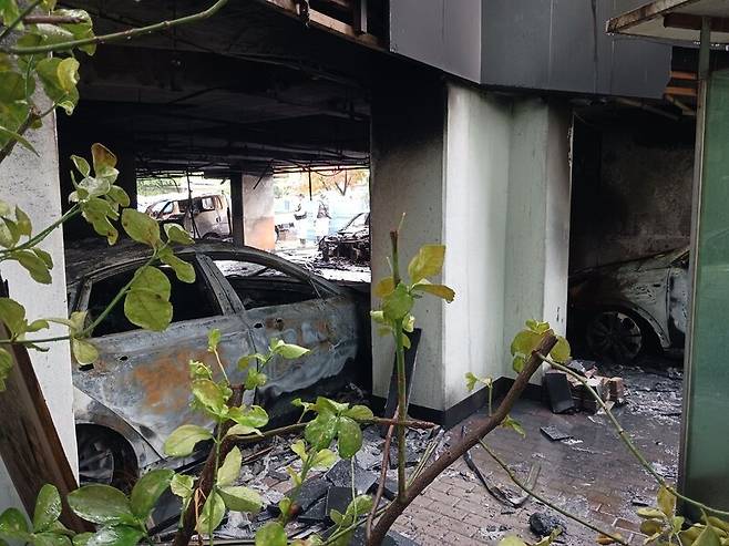 18일 경기도 광명시 소하동 아파트 화재 현장 1층 주차장에 차량이 불탄 채 놓여 있다. 이준희 기자