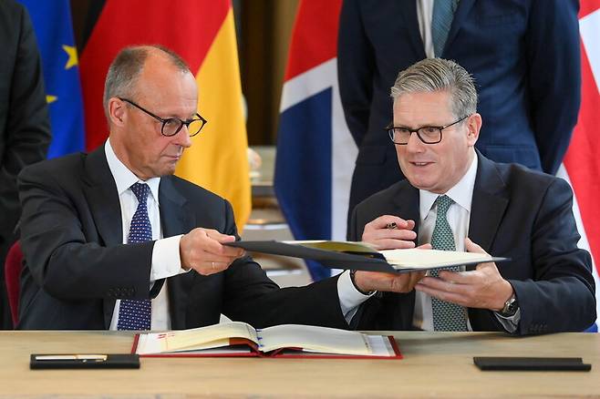 17일(현지시각) 프리드리히 메르츠 독일 총리(왼쪽)와 키어 스타머 영국 총리(오른쪽)가 런던 빅토리아 앨버트 박물관에서 ‘켄싱턴 협정’에 서명하고 있다. EPA연합뉴스