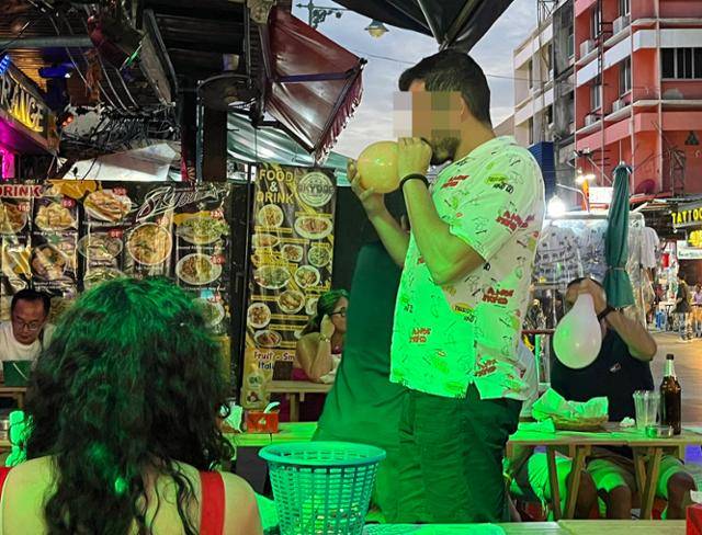지난해 7월 '배낭여행객의 성지'로 불리는 태국 방콕 카오산로드의 한 주점에서 외국인 관광객이 해피벌룬을 흡입하고 있다. 방콕=허경주 특파원