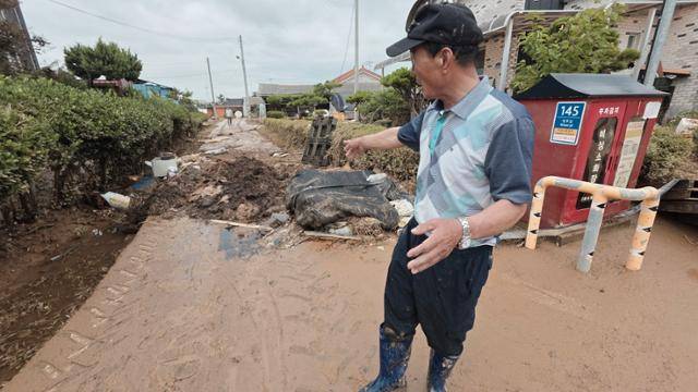 16~17일 내린 폭우로 침수 피해를 입은 충남 예산군 삽교읍 하포리 마을의 주민 이경호(72)씨가 흙탕물로 엉망이된 골목을 가리키며 긴박했던 전날 상황을 설명하고 있다. 예산=윤형권 기자