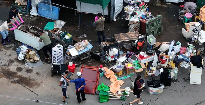 전날 내린 폭우로 침수 피해를 본 대구 북구 노곡동 한 가정집에서 18일 주민과 공무원들이 복구 작업을 하고 있다. 연합뉴스