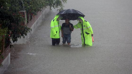 Police assist with the evacuation of a resident of Songjin 2-ri, Dochon-myeon, Changnyeong County, South Gyeongsang, on the afternoon of July 17. Changnyeong County sent out a disaster alert asking residents to move to a nearby community center after 272 millimeters (10.7 inches) of rain fell in Dochon between midnight and 3:55 p.m. [YONHAP]
