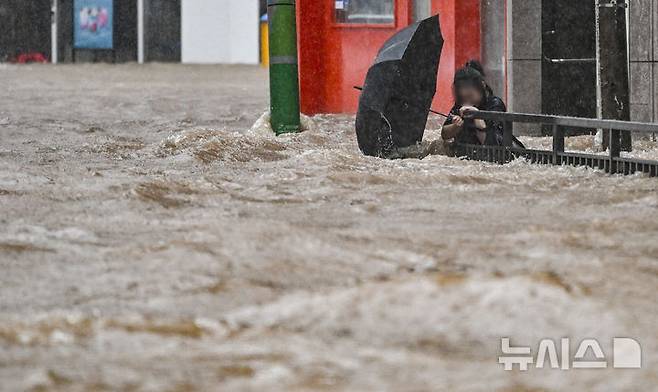 [광주=뉴시스] 이영주 기자 = 광주지역에 하루 최고 311㎜ 폭우가 쏟아진 17일 오후 침수된 광주 북구청 앞 도로에서 한 시민이 물살에 휩쓸리고 있다. 시민은 자력으로 무사히 대피했다. 2025.07.17. leeyj2578@newsis.com