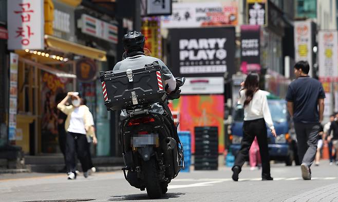서울 강남의 한 번화가에서 배달 라이더가 이동하고 있다. 연합뉴스