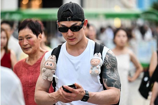 지난 4일 중국 상하이에서 한 남자가 라부부 인형이 매달린 가방을 멘 채 걸어가고 있다. AFP 연합뉴스